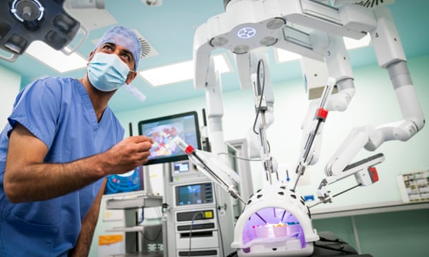 Scotland’s health secretary, Humza Yousaf, watches a surgical robot at work at Glasgow Royal Infirmary.