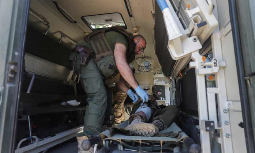 A military medic gives first aid to an injured Ukrainian serviceman close to a front line near the small city of Svitlodarsk of Donetsk area.