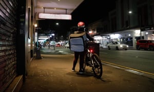 Food delivery bike rider with an insulated backpack on King Street Newtown. Sydney, Australia. Deliveroo, menulog, food. Take away.
