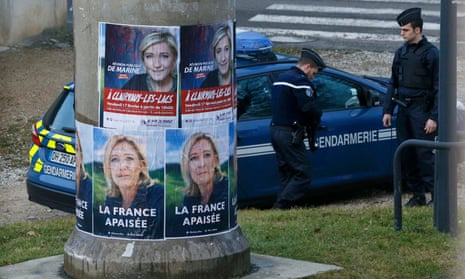 French gendarmes stand near Marine Le Pen campaign posters in Clairvaux-les-Lacs, eastern France.