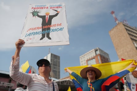 People hold signs and flags in Cali, Colombia.