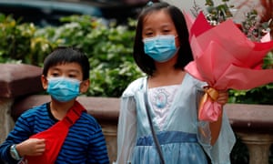 Children wear face masks on Valentine’s Day in Hong Kong, China February 14, 2020. REUTERS/Tyrone Siu