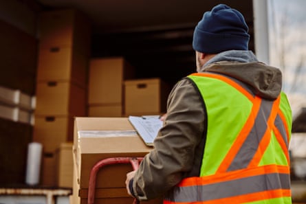 A delivery driver loading parcels into a van