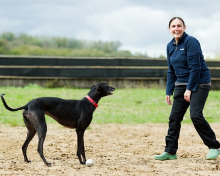 Cheerful-looking woman with a black greyhound