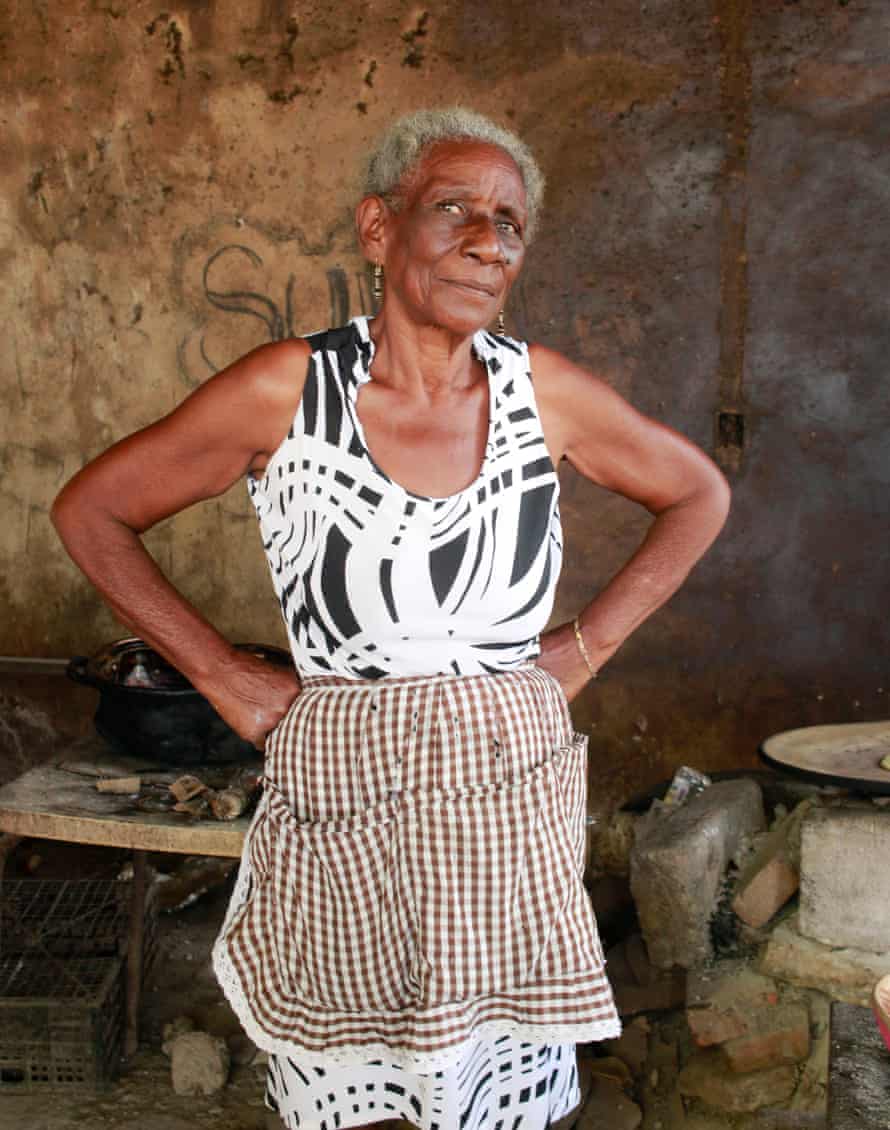 Abuela Hipolita stands proudly in front of her kitchen.