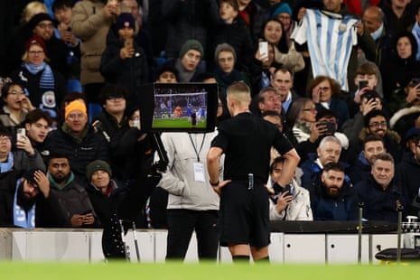 Referee Robert Jones checks the VAR screen after a handball by Kai Havertz of Chelsea.