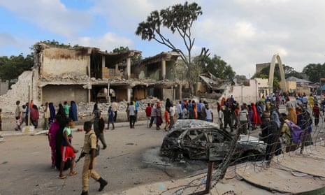 Residents gather to view the damage at the scene of a night car bomb attack in Mogadishu