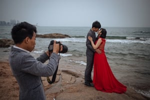 A couple pose for their pre-wedding photos in front of the Yellow Sea, in Qingdao