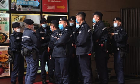 Police stand guard outside the Stand News office building in Hong Kong during a raid by police in December