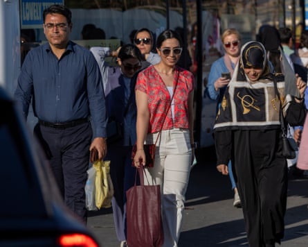 People walk along a street in Tehran