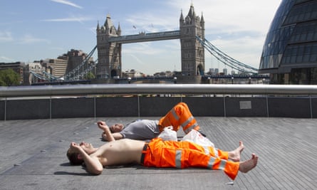 Workers take a break in the sun near Tower Bridge on Monday.