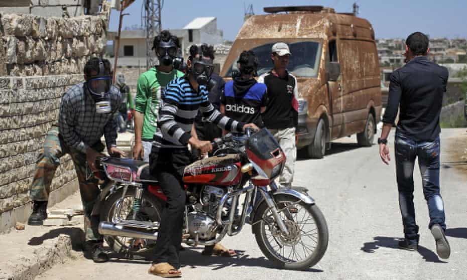 Civilians wear gas masks after a suspected chlorine gas attack on Kansafra village in Idlib province.