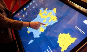 A woman touches a screen to access information about the senate elections at the senate in Paris.