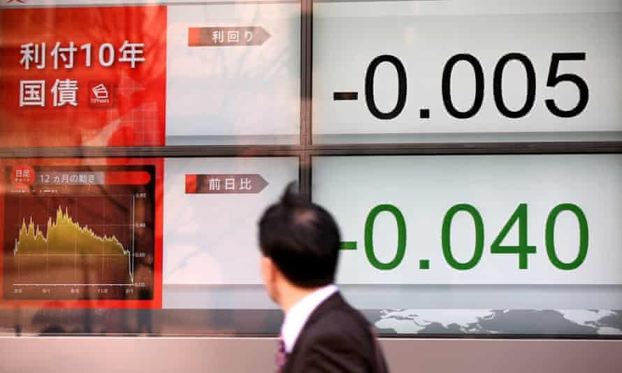 A commuter passes an electric display as the Japanese government’s 10-year bond turns negative for the first time last month.