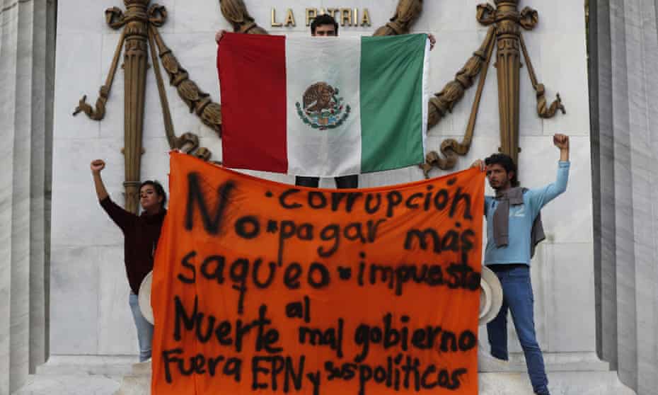 Protesters hold up a Mexican flag