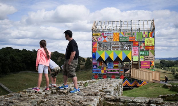 Members of the public walk around the work made out of temporary scaffolding.