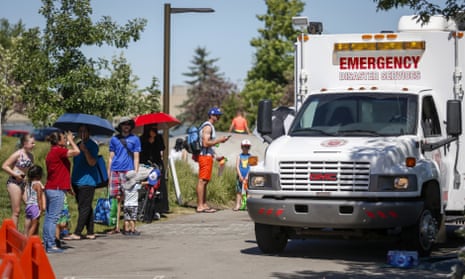 An emergency vehicle set up as a cooling station as people line up to get into a splash park in Calgary, Alberta