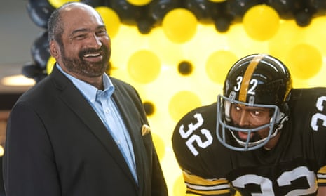 Franco Harris stands next to a statue of himself at Pittsburgh international airport in 2019.