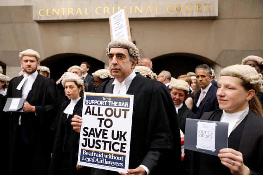 Criminal barristers protest in LondonPeople hold signs during a strike by criminal barristers outside the ‘Old Bailey’ in London, Britain, June 27, 2022. REUTERS/John Sibley