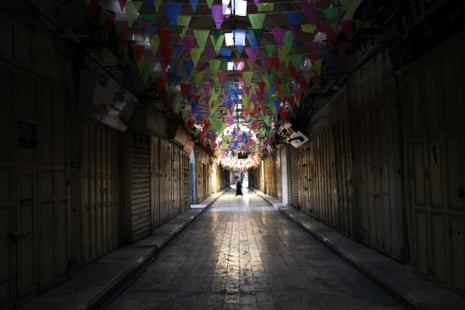 A Palestinian woman crosses an empty street during a general strike in the occupied West Bank city of Nablus