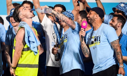 Jack Grealish drinks on stage following Manchester City’s open-top bus victory parade