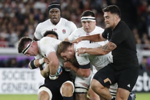 England’s Tom Curry, left, is tackled by the New Zealand defence.