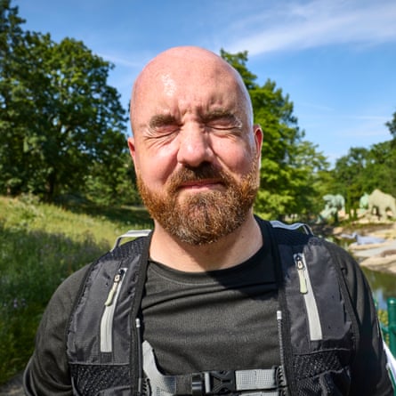 Ioan Marc Jones screws up his eyes in the park, with Victorian dinosaur models visible in the background