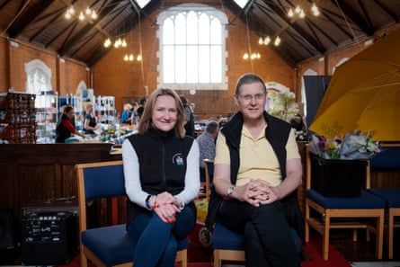 Sharon and Chris sitting on blue chairs inside a church