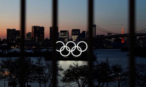 Los anillos olímpicos representados a través de una valla en Tokio.
