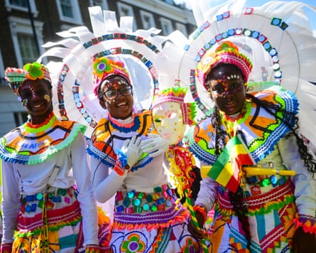 Three children in carnival costumes at Notting Hill carnival