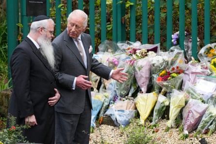 Rabbi Daniel Walker and King Charles talk next to floral tributes