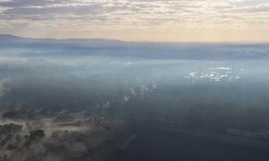 In the foreground is an open-cut coalmine near Queensland's Amberley air force base with the high rises of Brisbane on the horizon