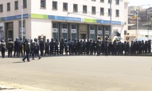Armed riot police block a main road during a patrol on the streets in Harare
