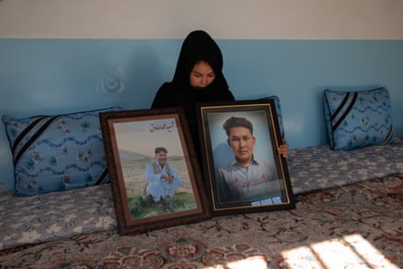 Masooma Yaqoob Ali holds a picture of her late brother Sadiq and her 17-year-old cousin Ahmed Shah, who had their throats slit by militants in Mach.