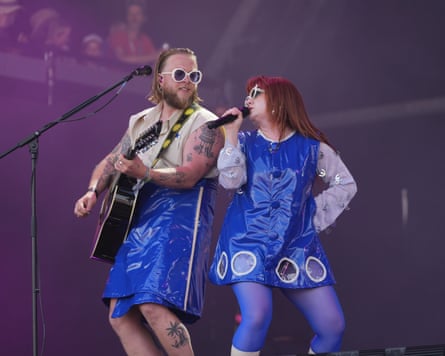 CMAT singing on stage with a man playing guitar