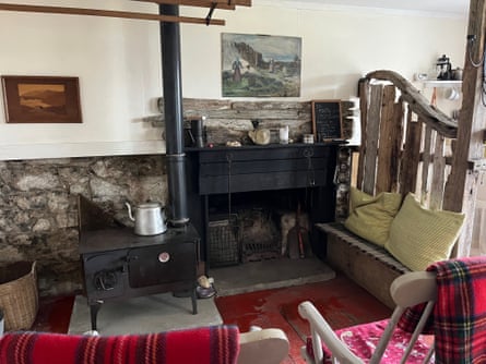 A black stove surrounded by wooden furniture with tartan blankets