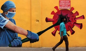 A man walks past a Covid-19 coronavirus awareness mural along the roadside in Chennai. Covid Awareness Mural in Chennai, Tamil Nadu, India.