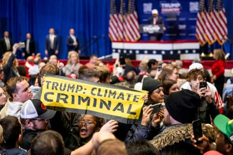 A protester holds up a sign that reads "Trump: climate criminal