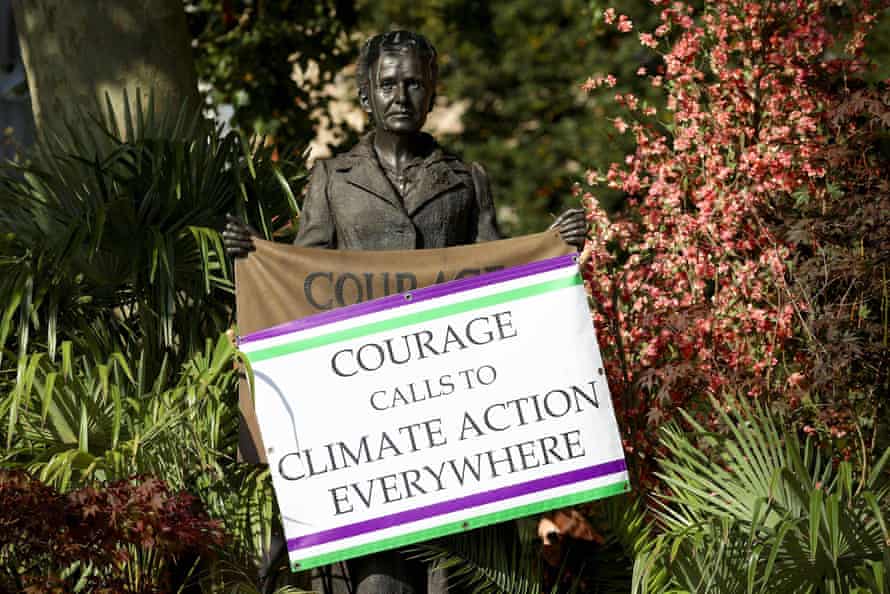 An environmental activist's sign reading 'Courage calls to climate action everywhere' on the statue of Millicent Fawcett in Parliament Square, London.