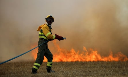 A firefighter tackles a blaze in a wheatfield in the province of Zamora, Spain, in July