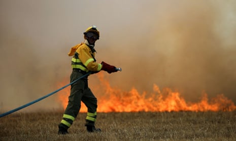 A firefighter tackles a blaze in a wheat field in the province of Zamora, Spain, in July