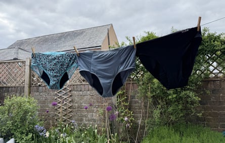 Three pairs of period pants (one turquoise leopard print, one grey and one black) hang on a garden washing line