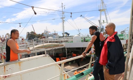 Dane Duplessis (right) and Cassiem Augustus (far right) advise a fisherman in Cape Town’s port.