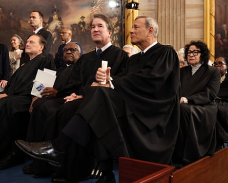 Blacked robed figures sit on a room