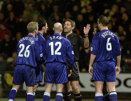 Several Gillingham players remonstrate with the referee Steve Baines.