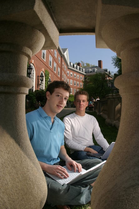 Facebook founders Mark Zuckerberg (L) and Chris Hughes on the Harvard University campus, with a laptop, seen through a stone balustrade, 2004