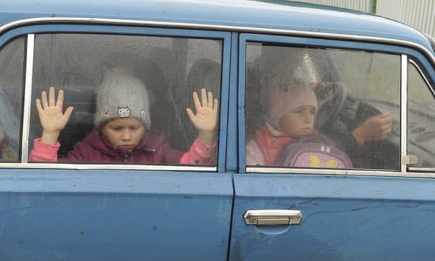 Refugee children from Kharkiv look through car windows as they arrive at a camp in Belgorod, Russia