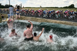 Stage 9, Chinon to Chateauroux Spectators jump in a makeshift swimming pool set up along the race route as the peloton cycles past.