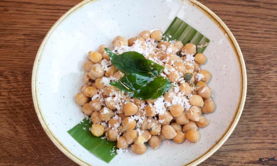 A sundal salad of coconut, peanuts and chickpeas on a round white plate