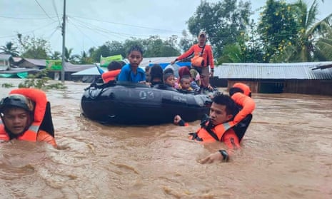 Philippine rescuers evacuate people from floods from Severe Tropical Storm Nalgae in Parang, Maguindanao province